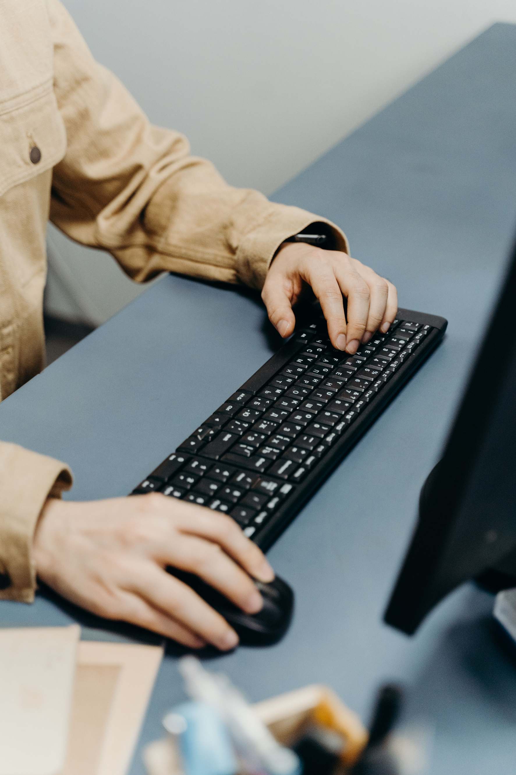 Hände tippen an einer Tastatur vor Tabellenblatt, keyboard office work